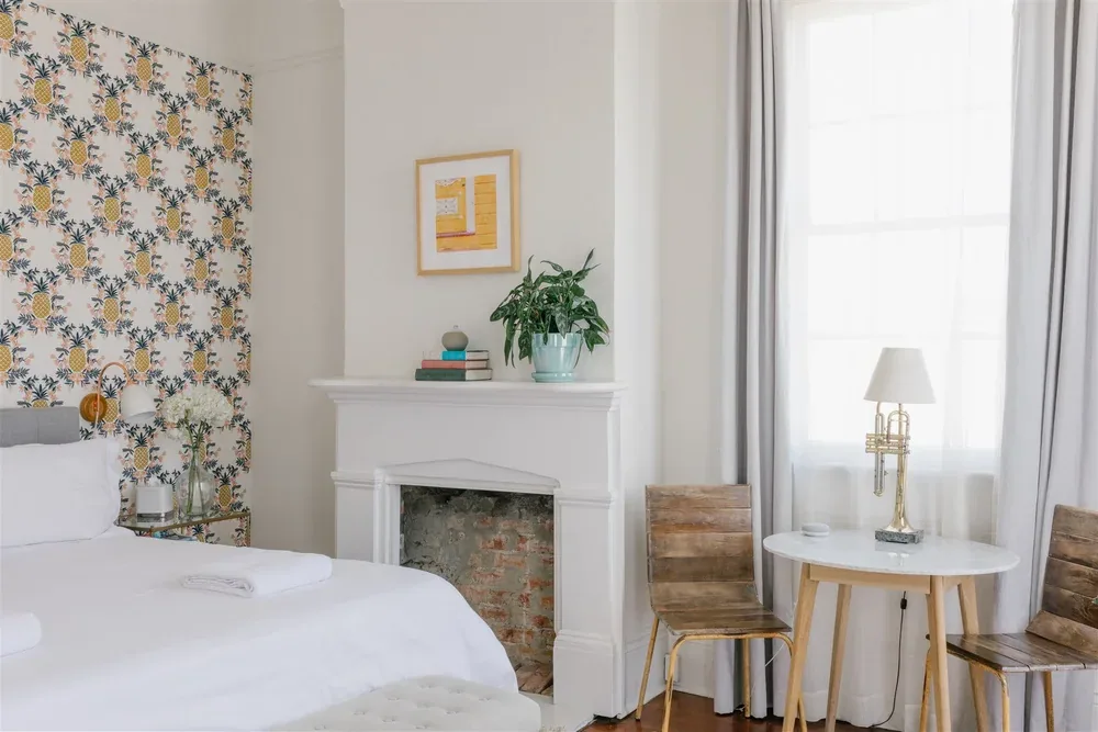 Bedroom with patterned wall and fireplace