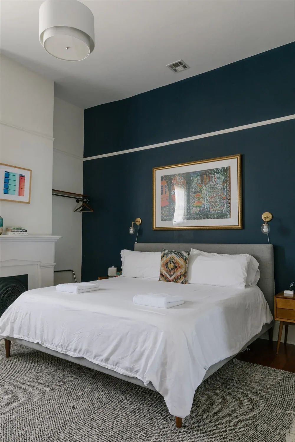 Blue bedroom with fireplace and art