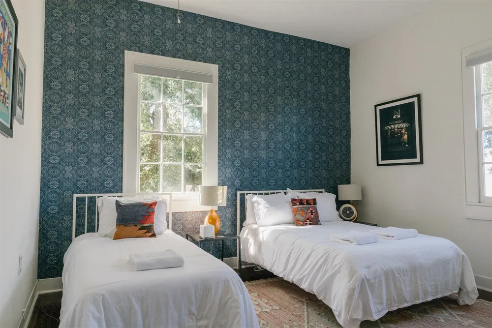 Twin bedroom with blue wall and framed art